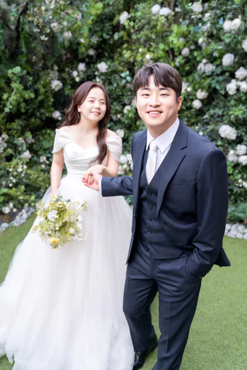 꽃이 가득한 정원에서 손을 잡은 임종훈과 김수현